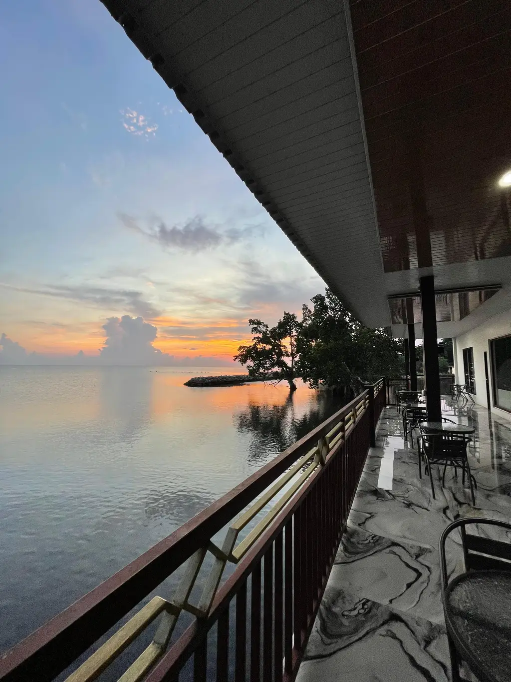 Morowali Beach Hotel — Waterfront restaurant balcony overlooking the Banda Sea at sunset