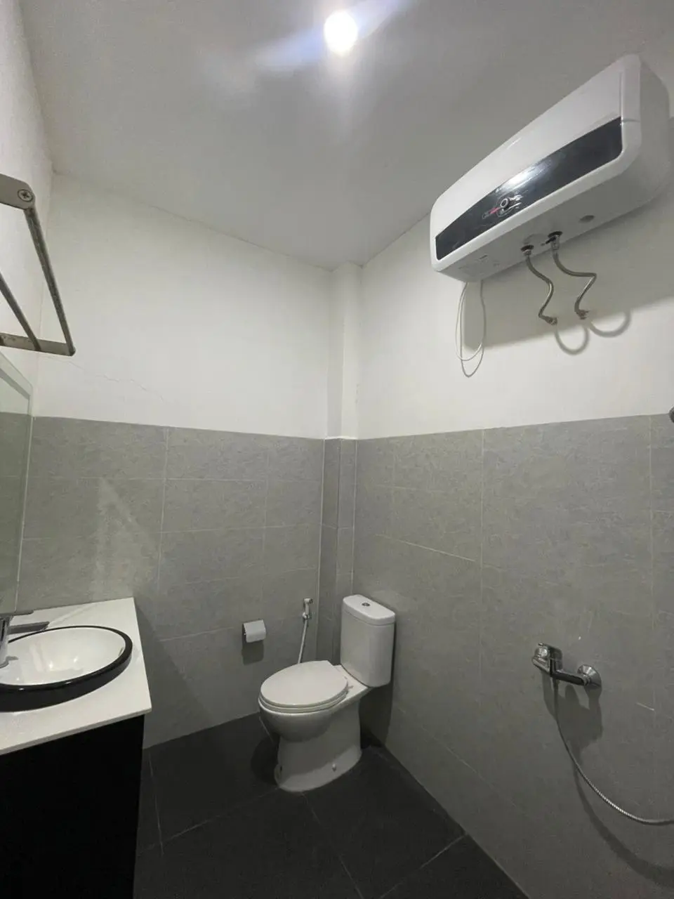 Functional and clean bathroom in a hotel suite room with grey tiles and modern fixtures.
