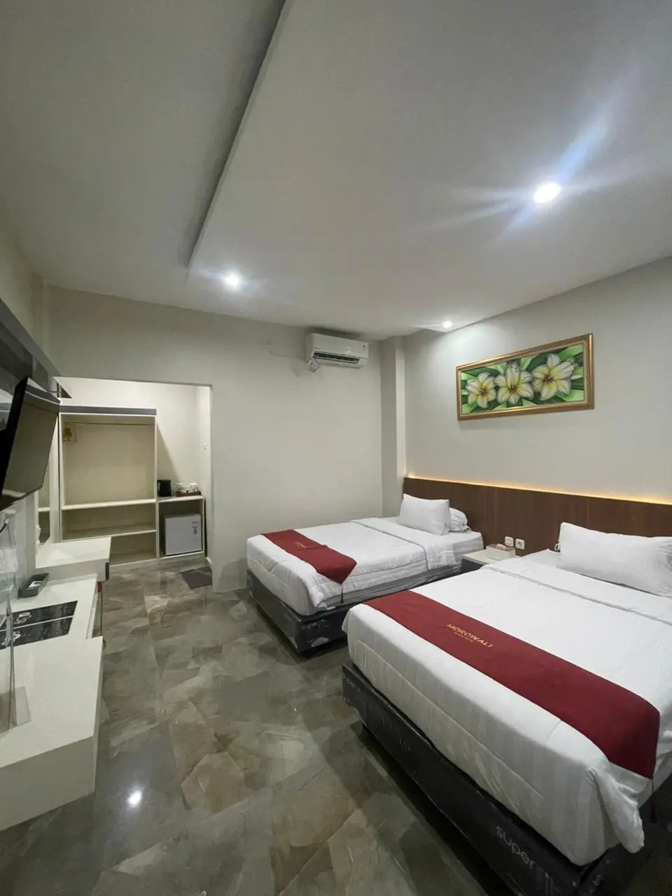 Modern Junior Suite room with two twin beds, white linens, and red bed runners.