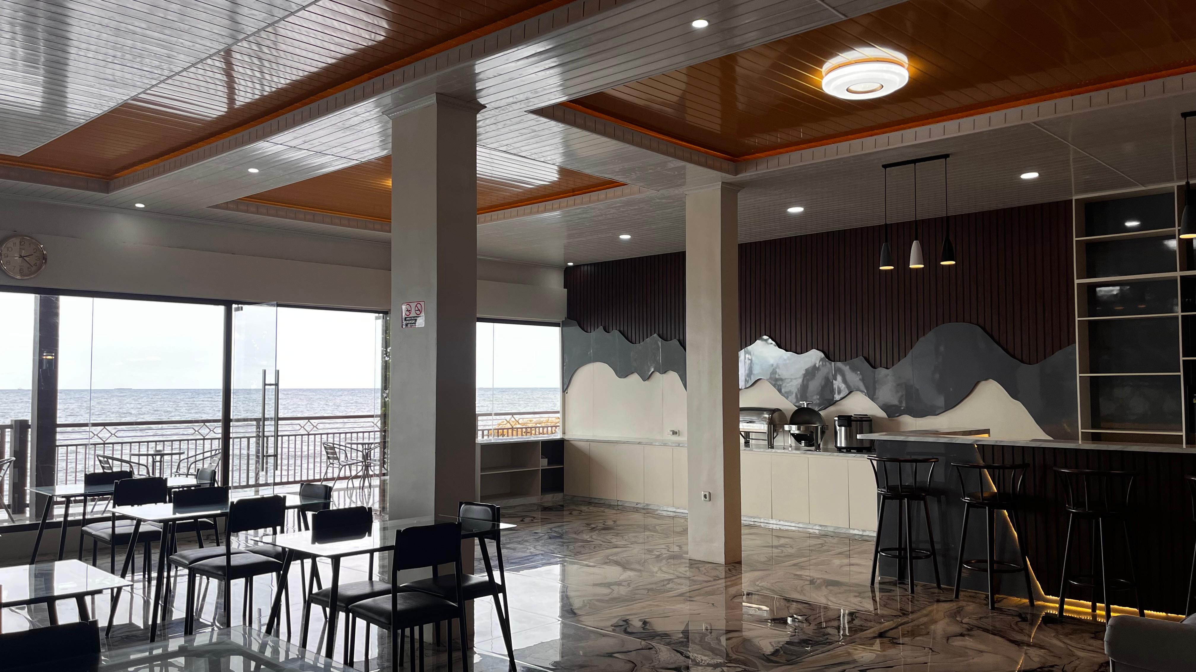 Modern hotel restaurant interior with marble floors and an expansive ocean view