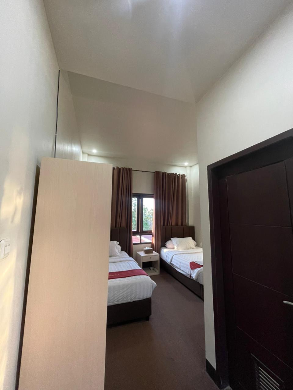 Kamar tipe Superior Twin dengan dua tempat tidur single dan linen putih.